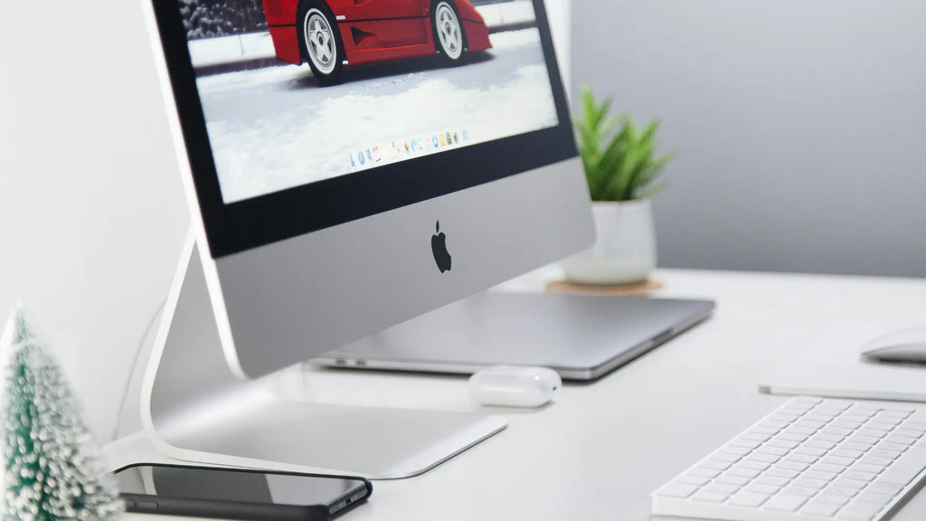 imac on desk with keyboard and iphone