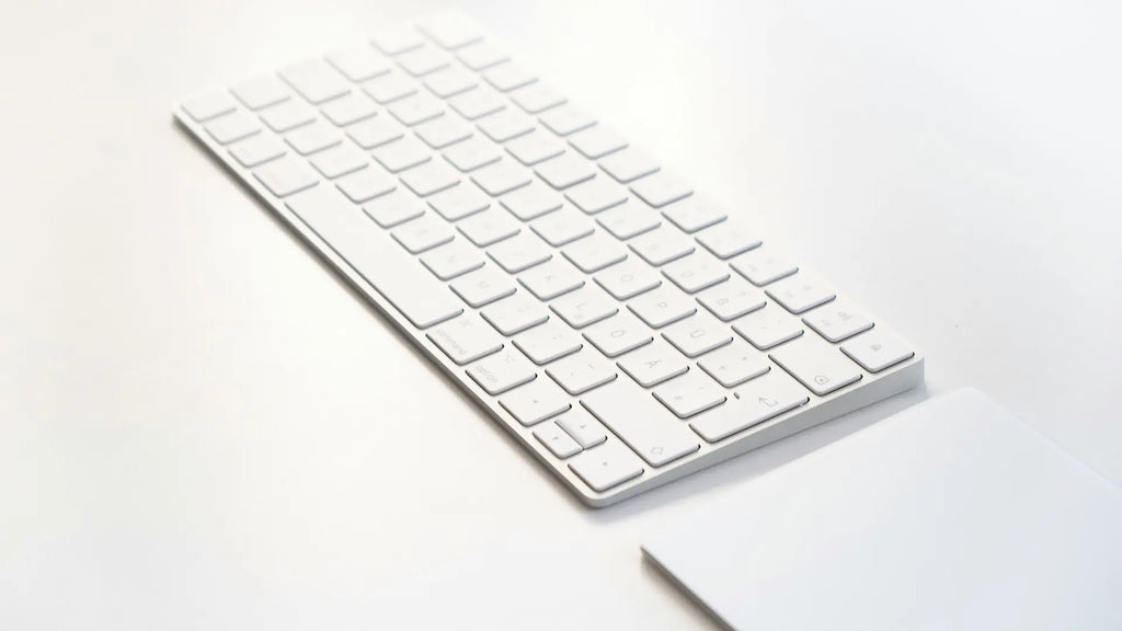 keyboard and magic trackpad on white desk