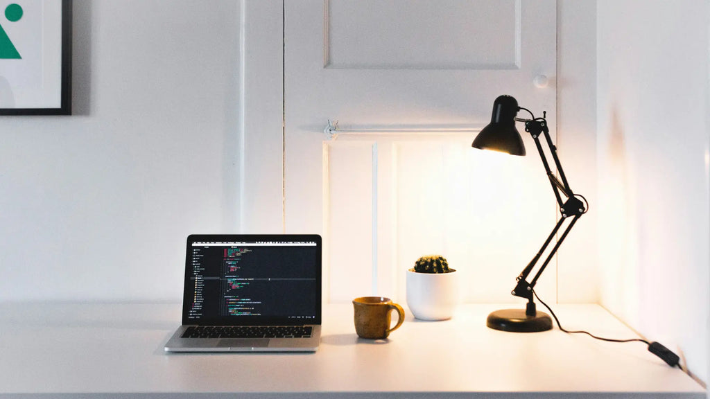 macbook with desk lamp on workdesk