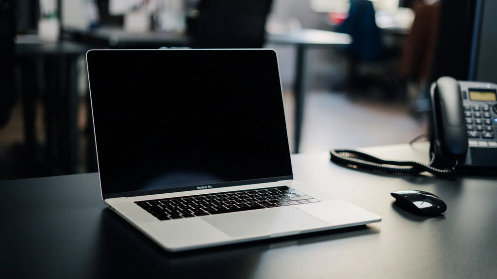 magic mouse next to a macbook on a desk