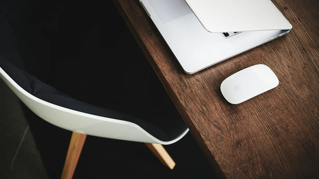 Chair by a workdesk with a Macbook and Magic Mouse