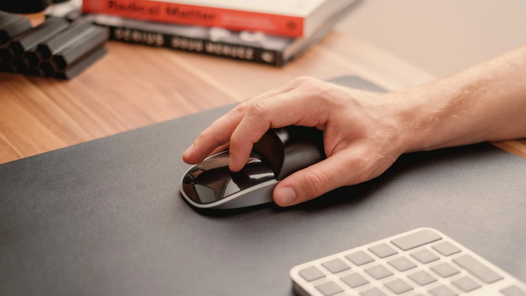 hand on the magic mouse with a solumics case
