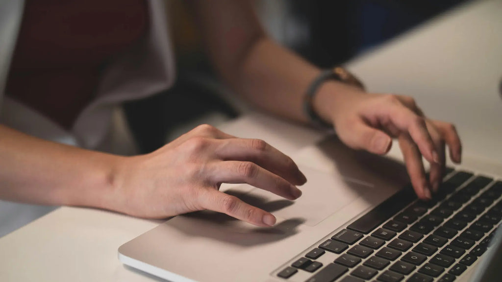 person using the trackpad on macbook