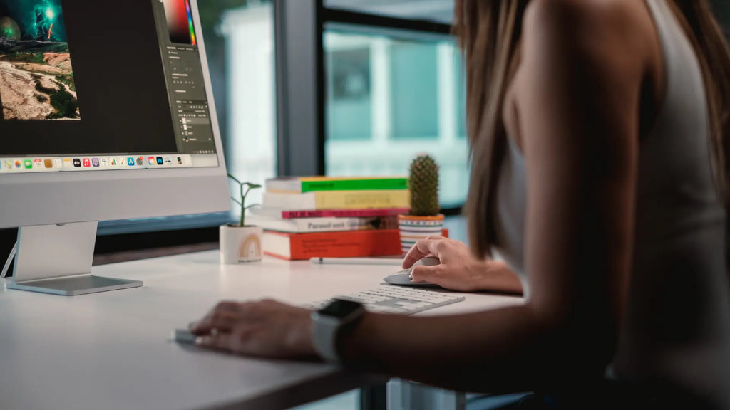 person working on imac with the magic mouse and solumics case