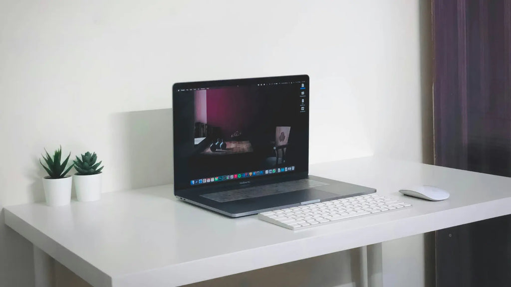 work desk with a macbook and magic mouse