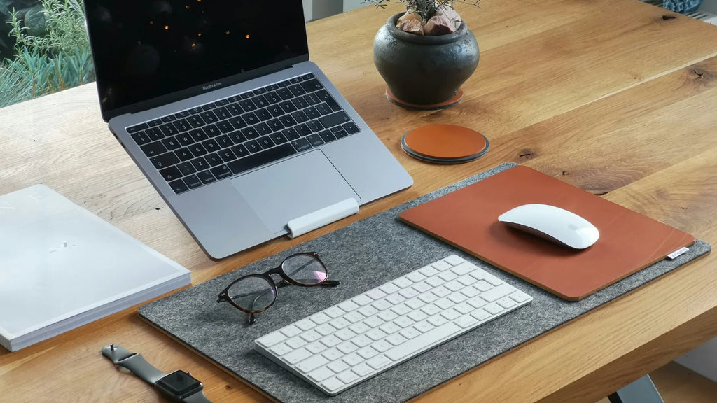 work desk with a macbook and magic mouse on a mouse pad