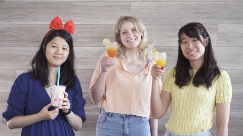 3 coworkers holding drinks and smiling