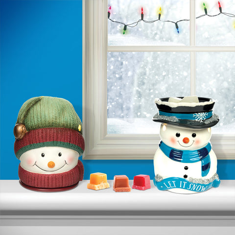 Snowmen wax warmers and wax cubes on a windowsill during a snowy day