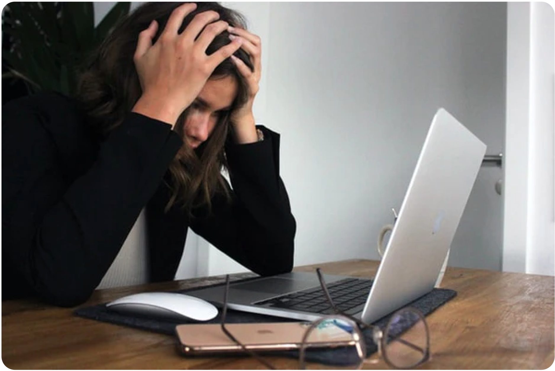 Verzweifelte Frau vor ihrem Laptop, sichtlich gestresst und von Schlafmangel gezeichnet, als Darstellung der körperlichen und emotionalen Belastung durch sauren Urin, der den pH-Wert des Körpers beeinflusst.