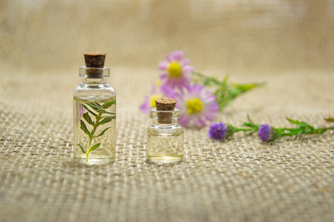 Two bottles with a flower behind