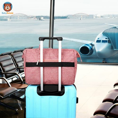 sac à langer sur une valise à l'aéroport pour partir en voyage avec bébé