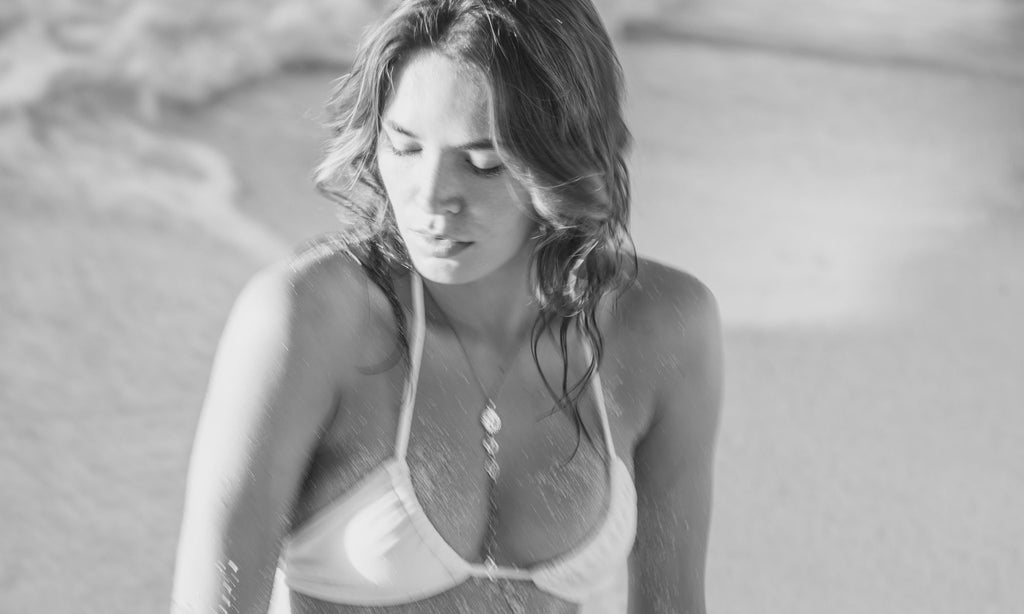 girl on beach wearing chakra necklace black and white