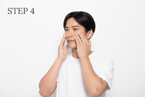 ご使用方法STEP4 - TooB ナチュラルスキンセラム を顔全体へ広げ、手で押さえて馴染ませている男性