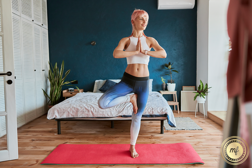 Woman smiling while practicing yoga in her room, enjoying relaxation and wellness
