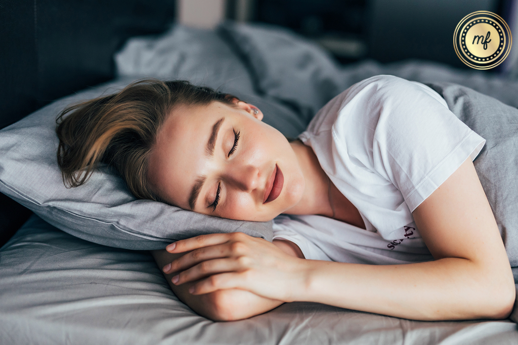 Serene woman asleep in bed, wearing a faint smile, portraying tranquil rest