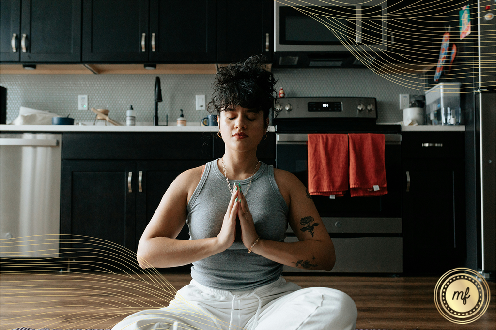 Woman in yoga attire practices yoga on kitchen floor, promoting mindful movement and wellness