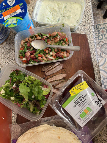 A box of salad leaves, reduced beetroot and reduced yoghurt making a money saving lunch.