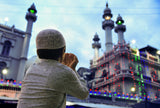 Young boy praying outside Mosque 