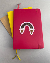 rainbow with ice cream cones for the clouds, on a journal notebook