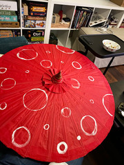 red parasol open with white dots outlined all over the surface
