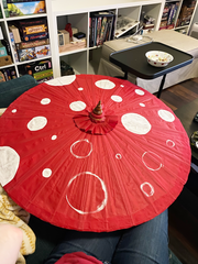 red parasol with half of the white dots painted in