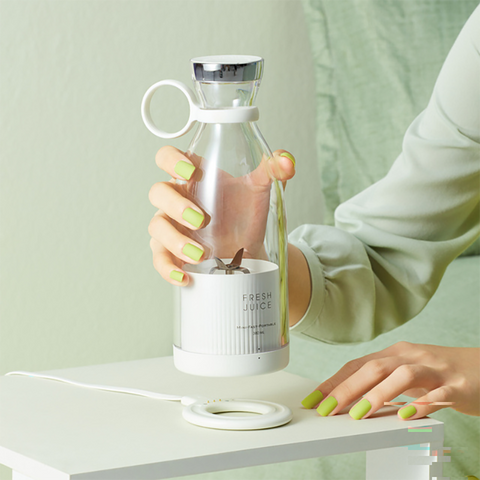 Person holding electric portable blende over the wireless magnetic charging port.