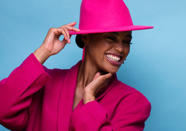 Model wearing pink monochromatic Valentino Garavani vintage suite and oversize statement earrings by Varily Jewelry in Viva Magenta pantone color of the year 2023