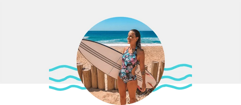 Bárbara com uma prancha de surfe na praia