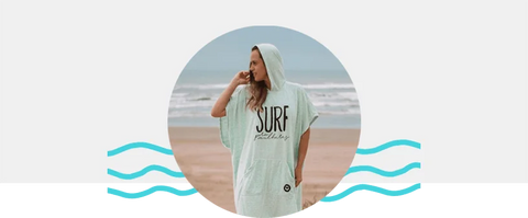 Lisa santorir usando um poncho de surfe na praia