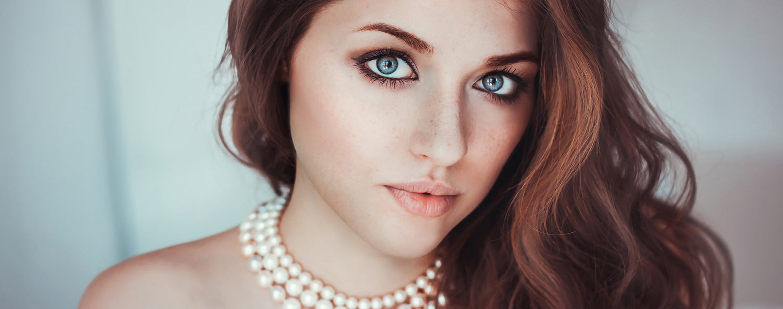 Femme avec un Collier de Perles Blanches