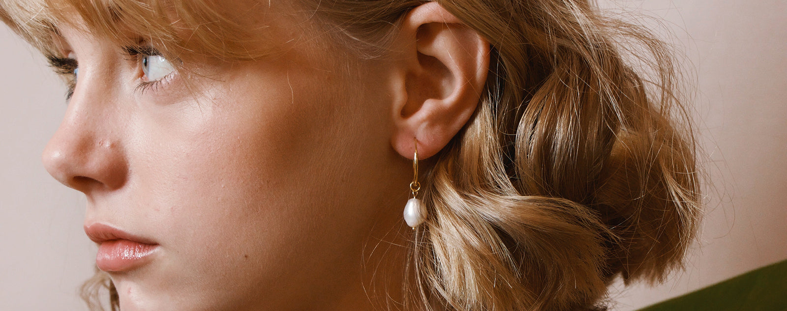Femme avec boucles d'oreilles perle de culture joli regard