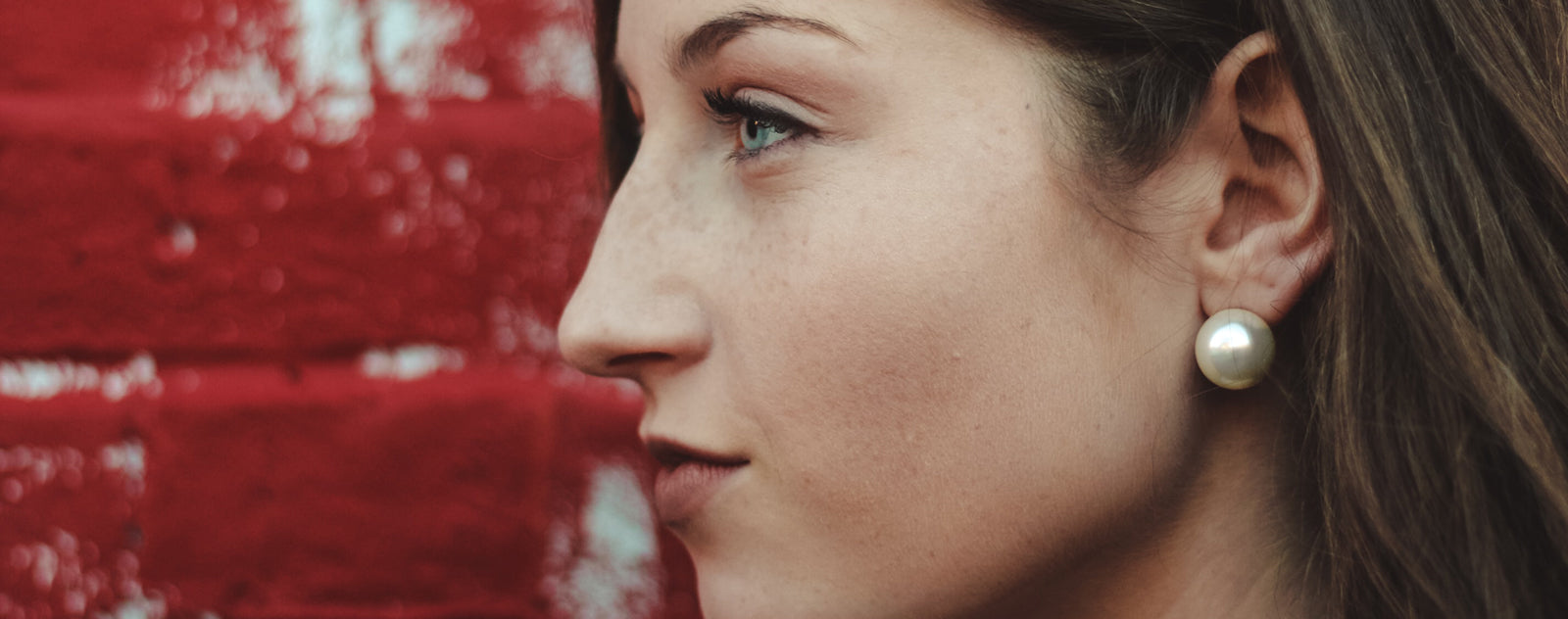 Femme avec une grosse boucle d'oreille en perle de nacre