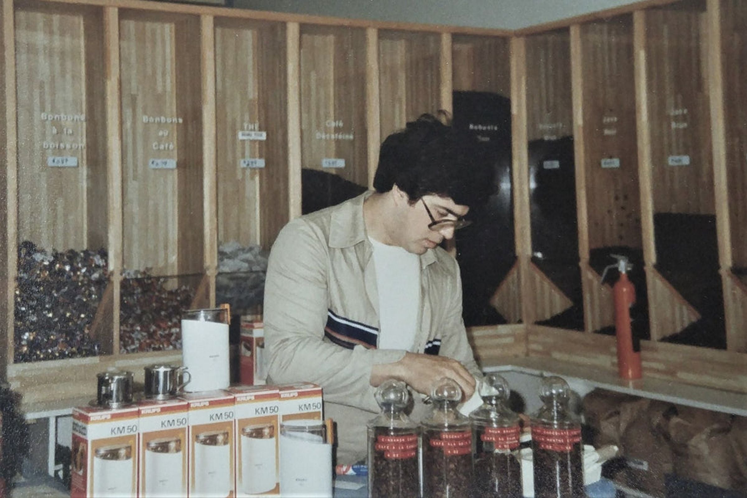 Carlo Granito, at 23, meticulously prepares coffee products at the early Terra Coffee & Tea shop in Montreal, 1978, embodying the values of quality and integrity.