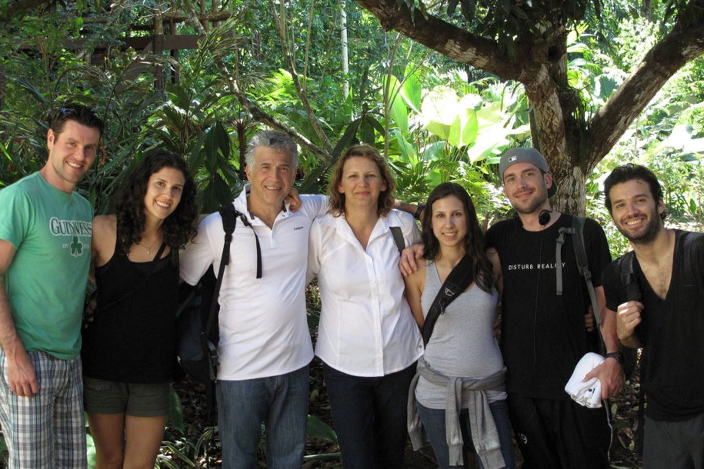 The Granito family together at a Brazil plantation, showcasing their connection and commitment to their coffee business amid a verdant setting.