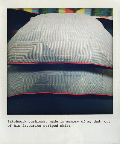two patchwork cushions on top of each other made of a blue and white striped shirt, with red piping