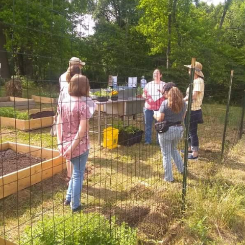 people teaching at a community garden