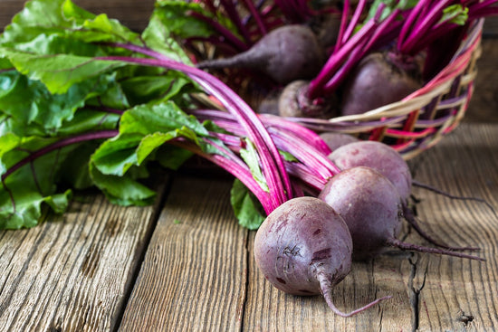 fresh beets with greens on table