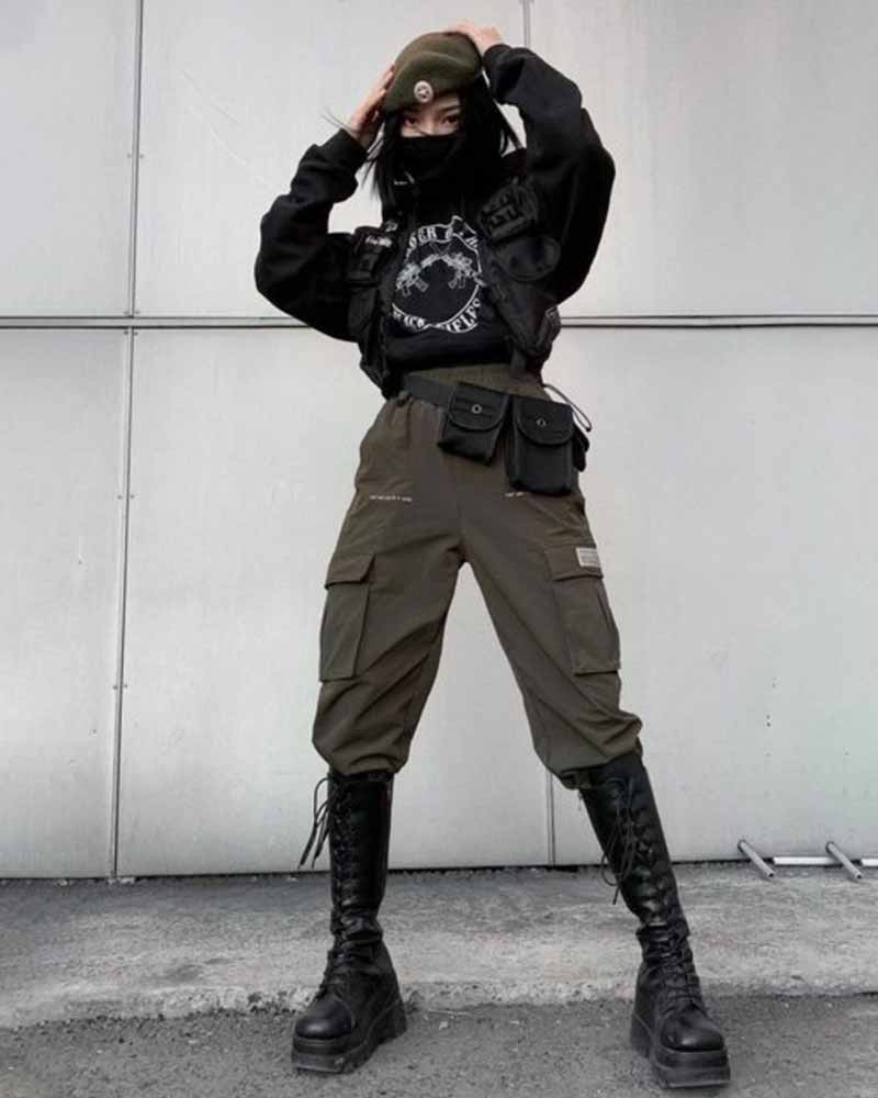 A woman wear tactical warcore bands with a military hat, techwear hoodie, and military women boots