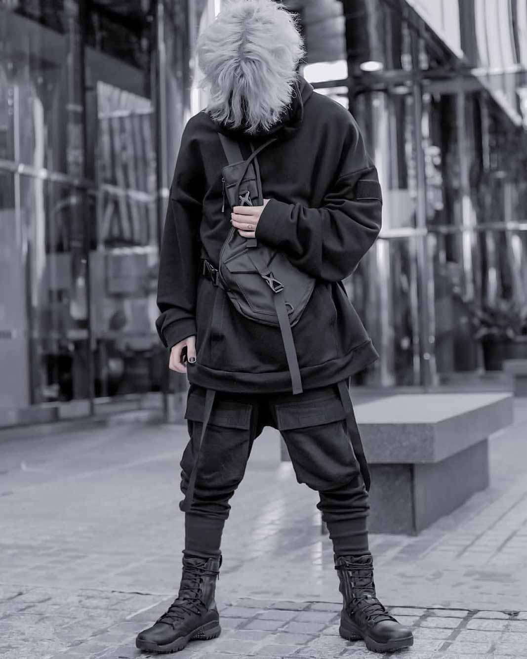 man wearing a techwear darkwear pants and a black hoodie