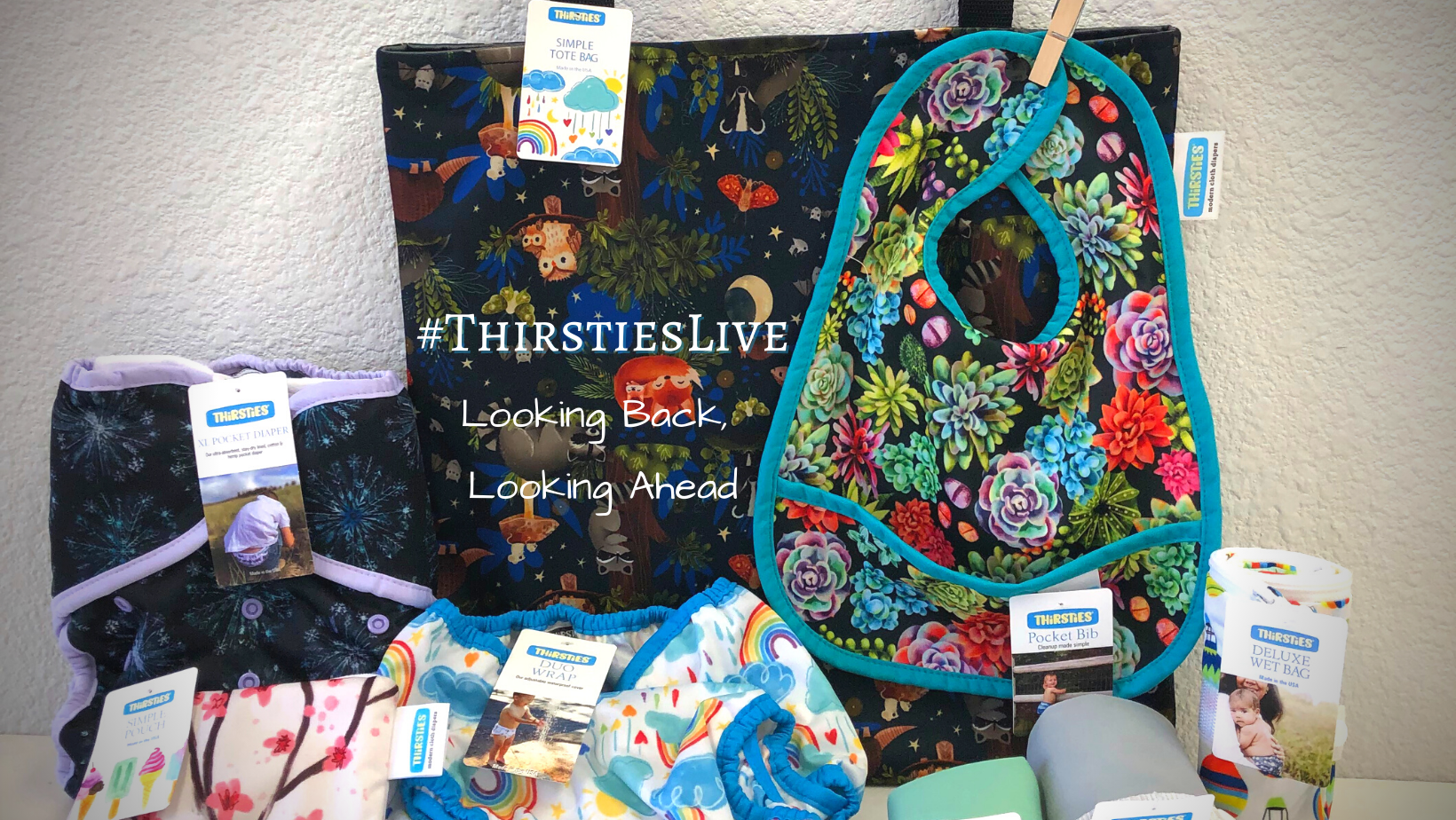 Thirsties New Products in 2021" and images of Thirsties products including pocket bib, deluxe wet bag, simple pouch, breast pad, simple tote bag, simple pail liner, menstrual pads, XL pocket diaper, and simple mini pail liner.