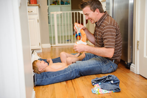 Sadler Merrill changing his daughter into a Thirsties cloth diaper