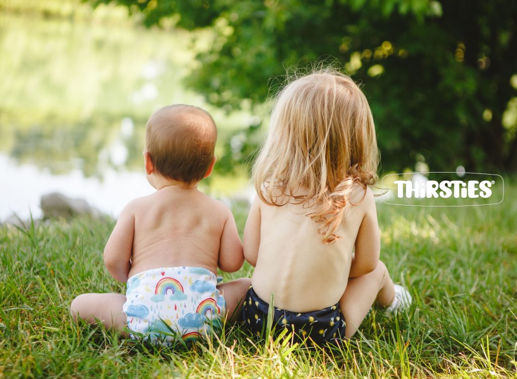 babies outside in diapers, the prints are rainbow and lightning bug