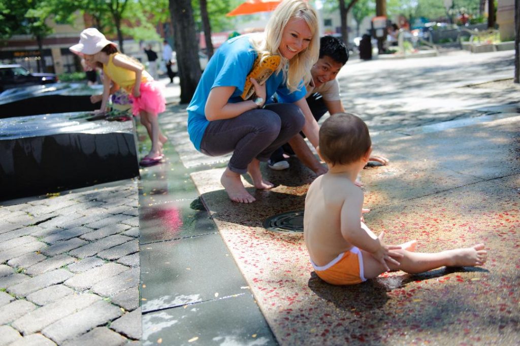 image of baby in a diaper outdoors with an adult