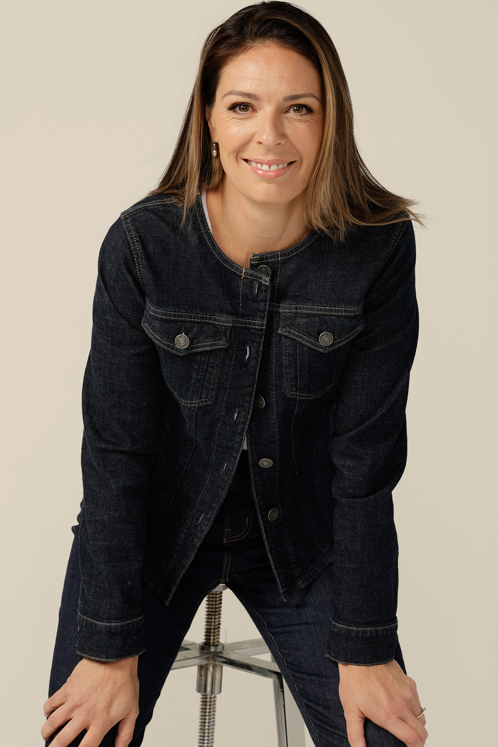 A collarless denim jacket in size 8 is worn with white bamboo jersey T-shirt and super-stretch skinny jeans. Consciously made from organic cotton, in partnership with Outland Denim, this denim jacket is tailored to fit women in sizes 8 to 24 by Australian and New Zealand women's clothing label, L&F.