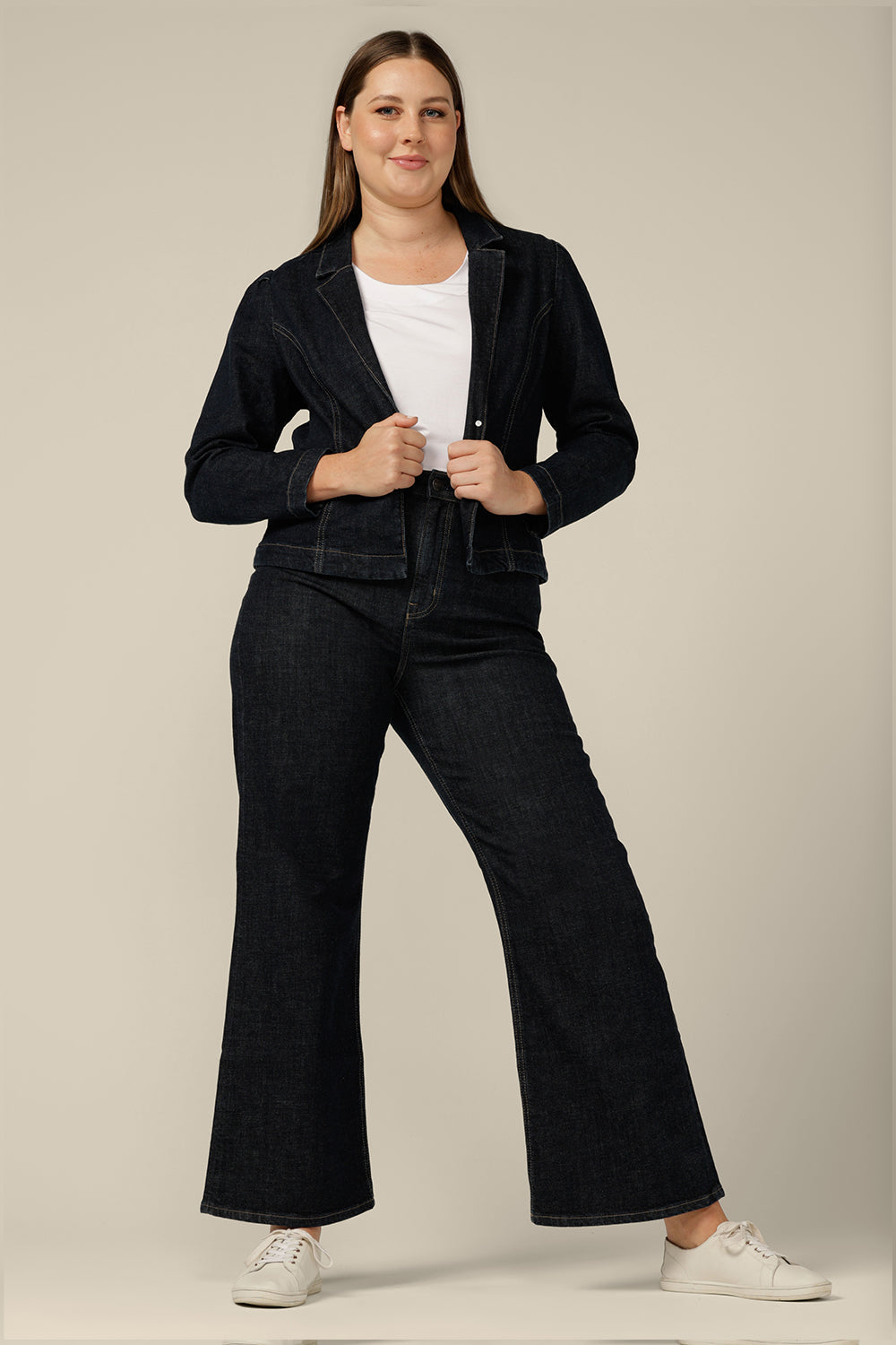 High-waisted, flared leg jeans in midnight denim, size 12. Ethically and sustainably made by Australian and New Zealand women's clothing brand, L&F, these well-fitting, comfortable jeans are worn with a denim jacket and white bamboo jersey T-shirt.