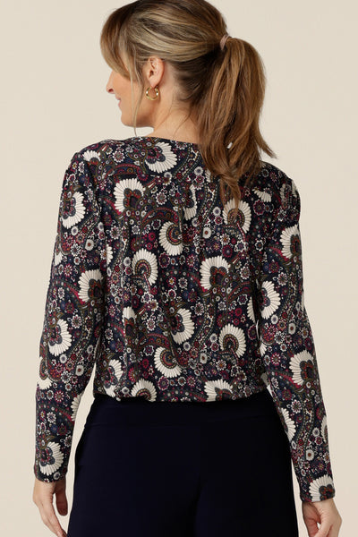 Back view of a size 10 woman wearing a long sleeve women's cowl neck top in paisley print jersey. The Chrissy Top in Midori is an easy fitting top on petite to plus size women. Made in Australia by Australian and New Zealand women's clothing label, L&F, this quality-made top is available to shop in an inclusive size range of 8 to 24.