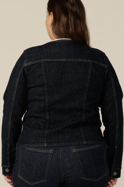 Back view of a collarless denim jacket in size 16, worn with white bamboo jersey T-shirt and super-stretch skinny jeans. Ethically and sustainably made in partnership with Outland Denim, this denim jacket is tailored to fit women in sizes 8 to 24 by Australian and New Zealand women's clothing label, L&F.