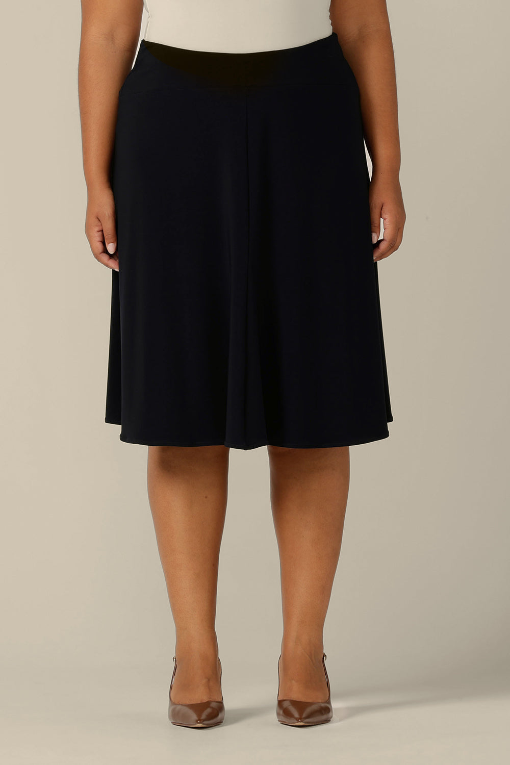 A fuller figure, size 18 woman wears a knee length pull-on skirt in navy jersey by Australian and New Zealand women's clothing brand, L&F. A classic skirt for comfortable work wear or smart casual wear.