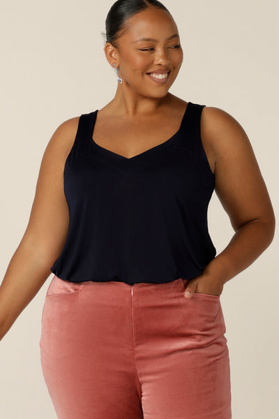 A size 18, fuller figure woman wears a navy cami top with wide shoulder straps. Made in Australia by Australian and New Zealand women's clothing brand, L&F,  this slinky jersey top wears well with evening and occasionwear skirts, pants and suit jackets.