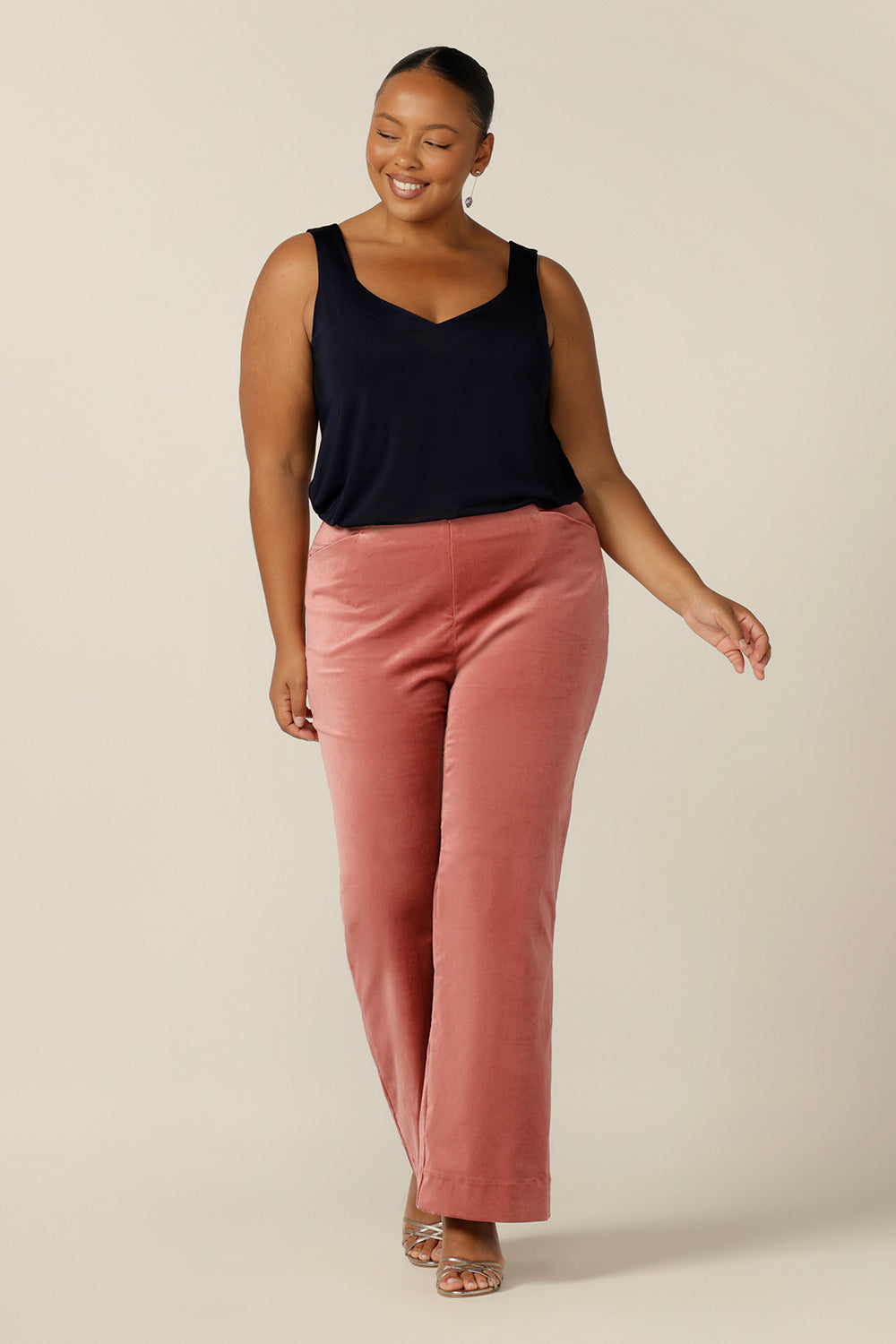 A size 18, plus size woman wears a navy cami top with wide shoulder straps together with flared velvet trousers.. Made in Australia by Australian and New Zealand women's clothing brand, L&F, this slinky jersey top wears well with evening and occasionwear skirts, pants and suit jackets.